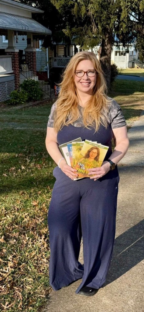 Annie Stewart Lambert holding her published books, The Fig Tree Series, available on Amazon. 